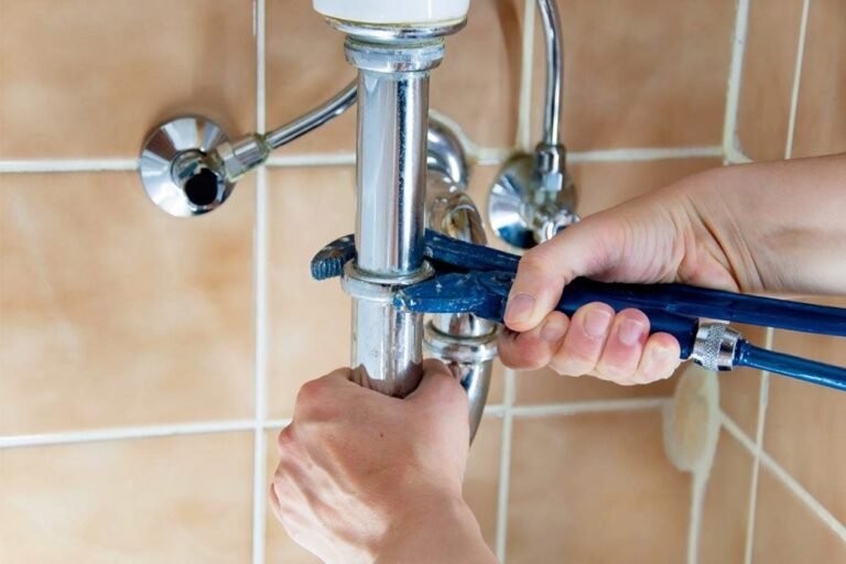 plumber fixing a water pipe in a bathroom