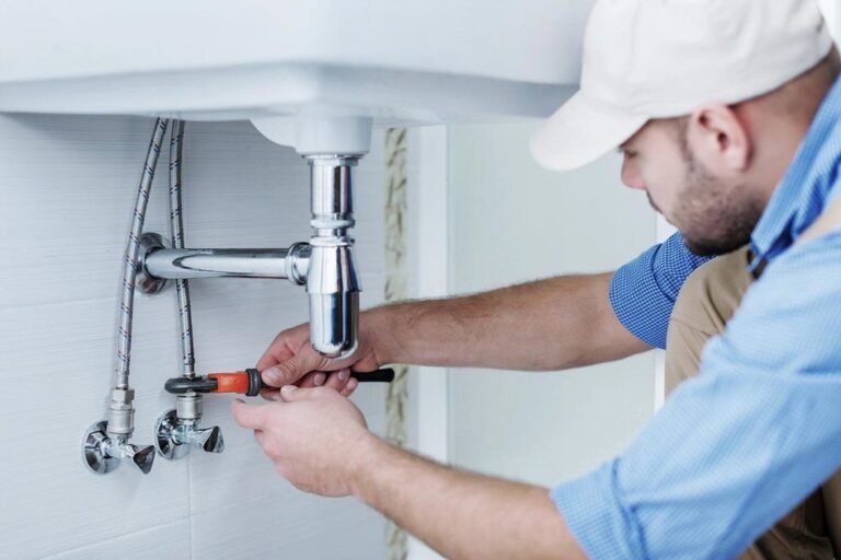 plumber fixing sink plumbing in California home