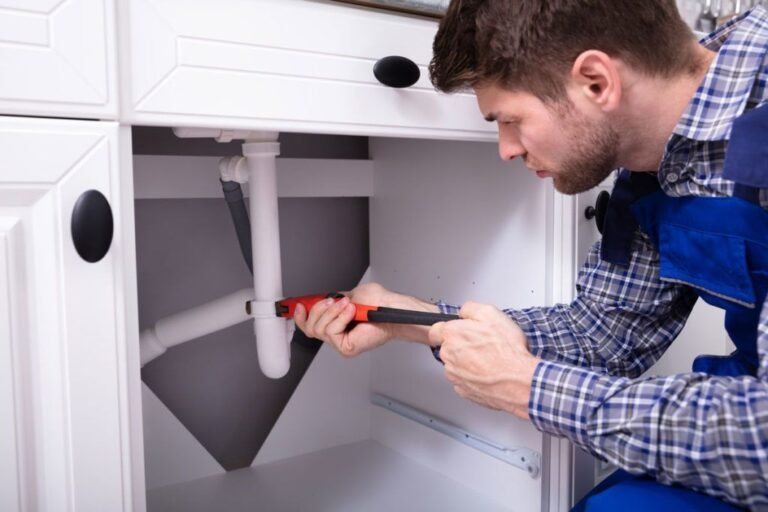 plumber repairing the sink plumbing in a residential property