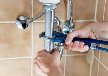 plumber fixing a water pipe in a bathroom